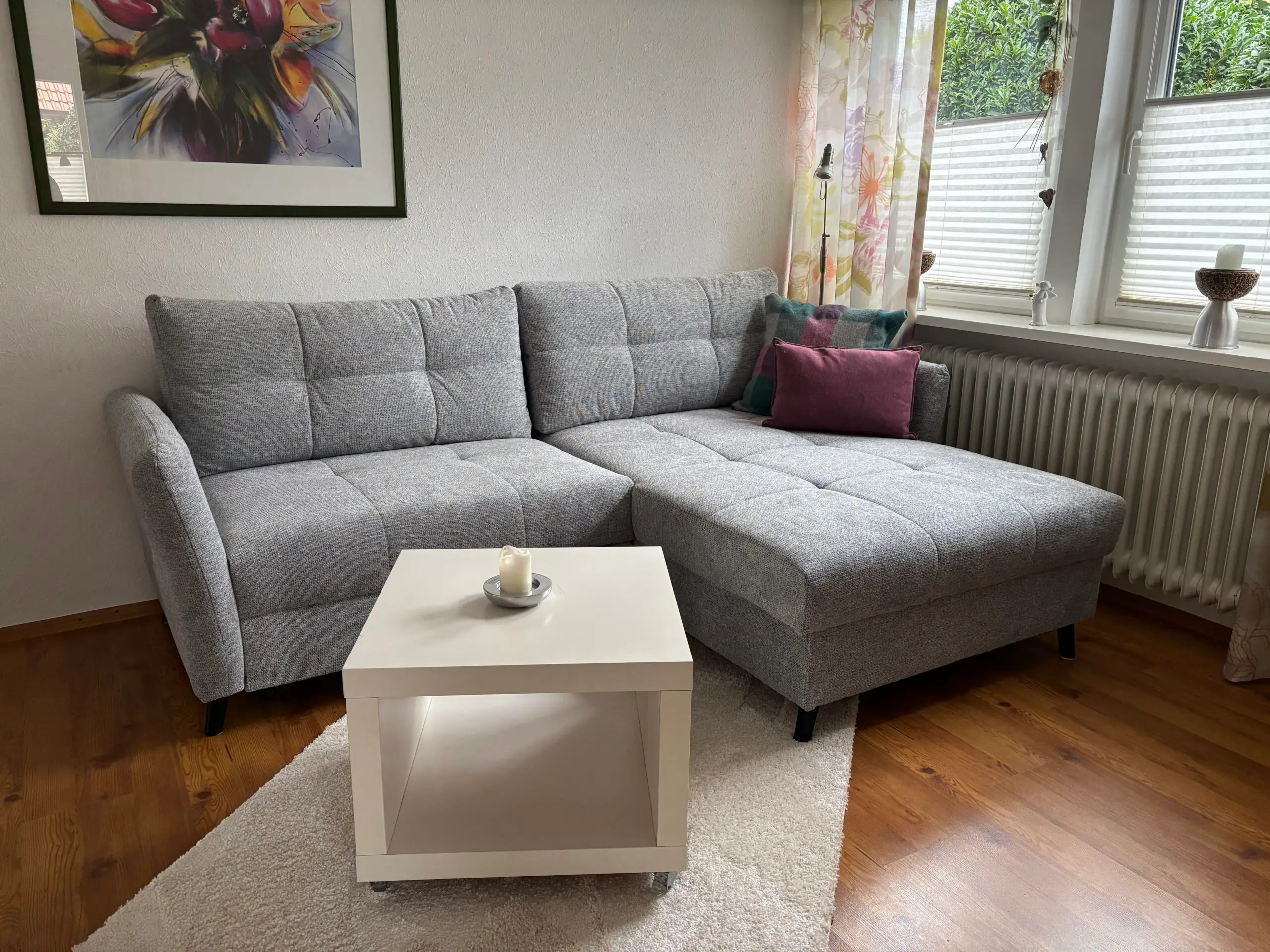 Wohnzimmer mit grauem Ecksofa und Couchtisch