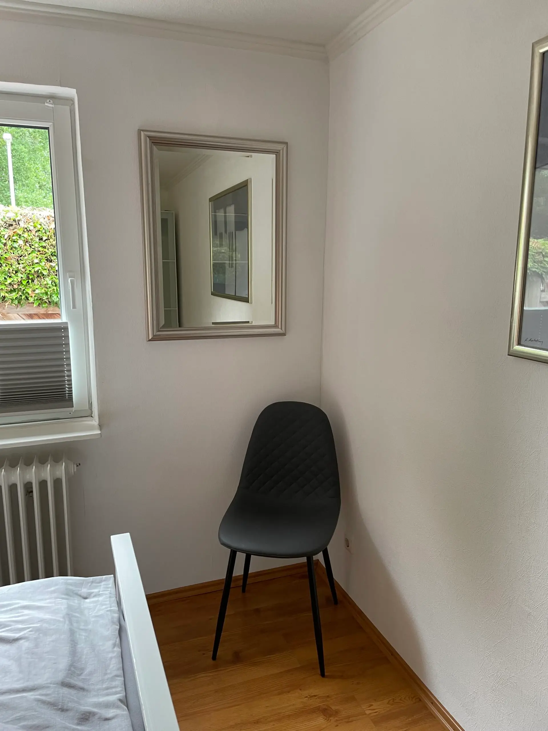Zweites Schlafzimmer mit Stuhl und Spiegel